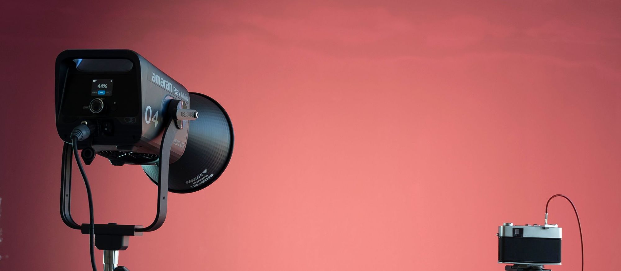 LED studio light on a stand in front of a red backdrop