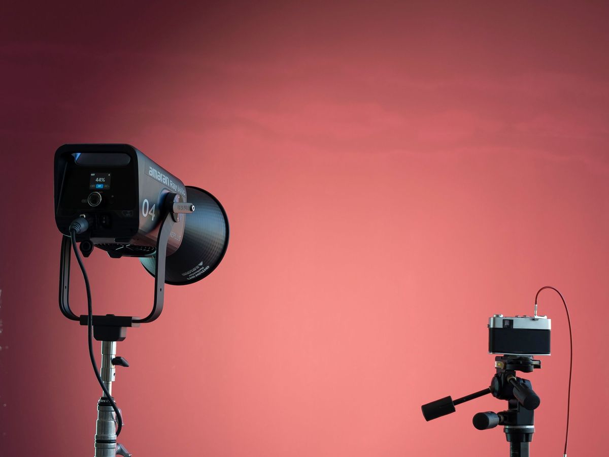 LED studio light on a stand in front of a red backdrop